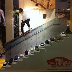 a skateboarder is riding down an escalator in a store with shoes on it