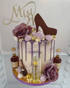 a cake decorated with purple icing, flowers and a high heel shoe on top