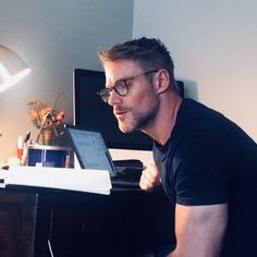 a man sitting at a desk using a laptop computer