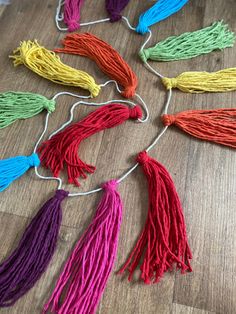 colorful tassels are laid out on the floor to be used as decorations or wall hangings