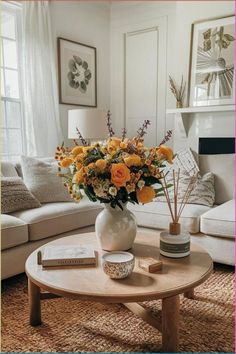 a living room filled with furniture and flowers on top of a coffee table in front of a window