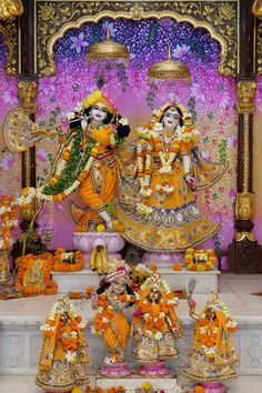 an idol is displayed in front of a stage with flowers and other decorations on it