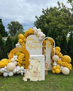 a winnie the pooh themed birthday party with balloons and decorations in yellow, white and grey colors