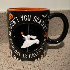 a black and orange coffee mug with an image of a ghost on the front, says aren't you scared every friday is halloween