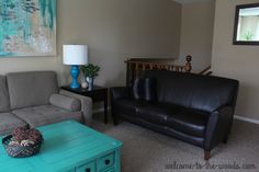 a living room with two couches and a coffee table in front of a painting