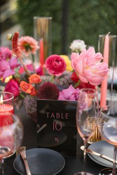 the table is set with flowers, candles and place cards for guests to sit at