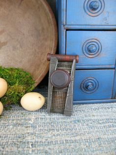 an egg slicer sitting next to some eggs on the ground near a blue dresser