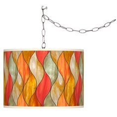 a lamp hanging from a chain on a white wall with an orange and yellow shade