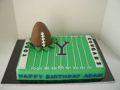 a football themed cake is displayed on a table