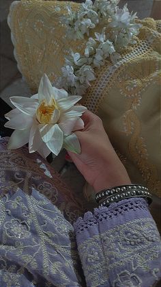 a woman's hand holding a white flower