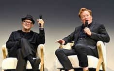 two people sitting in chairs with microphones