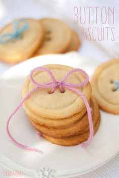 some cookies on a white plate with pink string