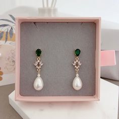 * DETAILS * - Emerald Crystal Glass Post Earrings - Aquamarine Crystal Glass post Earrings  - Teardrop Shaped Synthetic White Pearls  Metal: Bright / shiny gold plated brass 🎁A designer pull drawer pink gift box is available when the gift wrapping option is chosen. ------------------------------------------ * CARE TIPS * ⭐️TO PREVENT TARNISH: Keep your jewellery in airtight plastic bags. It won't tarnish if it isn't exposed to air. The worst place to leave your jewellery is in a steamy bathroom. Wipe with a soft cloth after wearing. - Perfumes: Be sure any perfume or lotions are completely absorbed into skin. - Hair products: Apply all hair products before putting on jewelry. - Swimming: Remove all jewelry before swimming or getting into hot tubes. - No sunlight: Store away from heat, dir Green Teardrop Pearl Earrings For Wedding, Green Dangle Clip-on Earrings For Wedding, Green Drop Pearl Earrings For Wedding, Classic Green Earrings For Wedding, Elegant Green Clip-on Earrings For Wedding, Green Clip-on Earrings For Wedding, Elegant Green Pearl Drop Bridal Earrings, Green Clip-on Wedding Earrings, Pink Gift Box