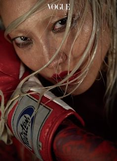 a close up of a person wearing red boxing gloves with the words voge on it