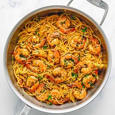 pasta with shrimp and parsley in a pan on a marble countertop, ready to be eaten