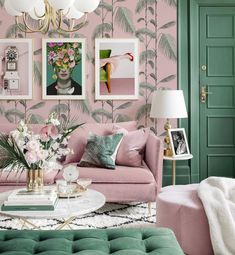 a living room with pink and green furniture, pictures on the wall and palm trees