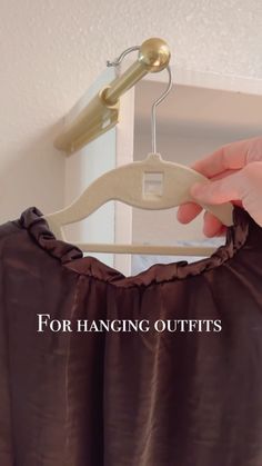 a person is holding a hanger over a dress