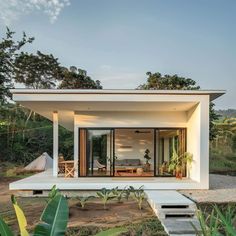 a small white house sitting on top of a lush green field