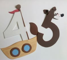 a paper cut out of the shape of a sailboat and a dog on it