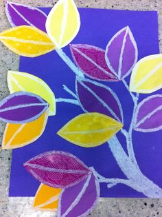 an art project made with colored crayons and paper leaves on a purple background