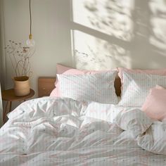 an unmade bed with pink and white sheets