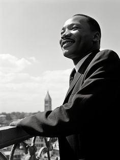 a black and white photo of a man in a suit looking off into the distance