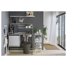 a white and gray room with some shelves on the wall next to a trash can