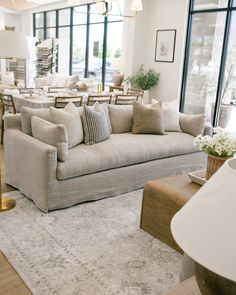 a living room filled with lots of furniture and decor on top of a white rug