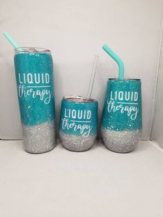 three blue and silver tumblers with liquid therapy written on them