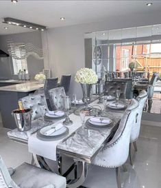 a dining room table set with silver chairs