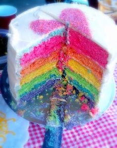 a multi - colored cake with one slice cut out