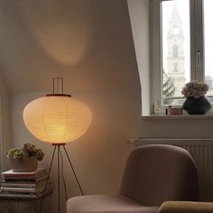 a living room with a lamp on the floor next to a chair and bookshelf