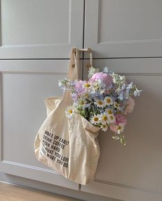 a tote bag with flowers hanging from the handle on a door way hanger