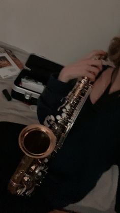 a woman sitting on the floor playing a saxophone