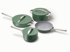 three green pots and pans on a white surface