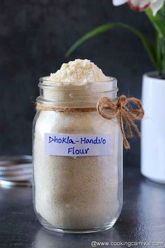 a jar filled with white powder next to a flower