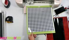 a person is using a machine to cut fabric on a piece of paper with scissors