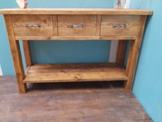 a wooden table with two drawers on one side and a shelf on the other end