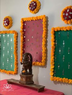 there is a small statue in front of some colorful wall hangings with beads on them