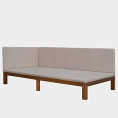 a white couch with wooden legs and a beige upholstered back rest on a gray background