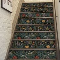 the stairs are decorated with flowers and plants on them, along with pictures hanging on the wall