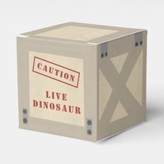 a cardboard box with an image of a dinosaur on the front and words caution live dinosaur in red