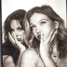 two beautiful young women posing with their hands on their face and one holding her mouth open