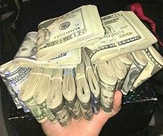 a person holding a stack of twenty dollar bills