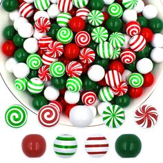 a white bowl filled with candy canes and candies on top of a table