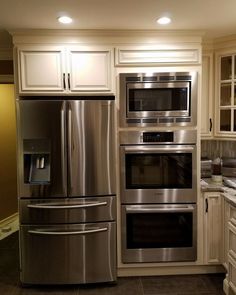 a kitchen with stainless steel appliances and white cabinets