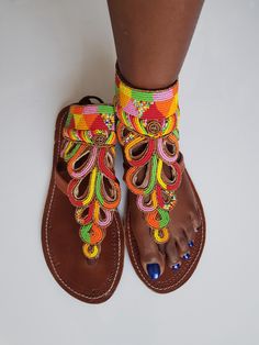 Maasai sandals made with high quality black leather and colorful fine beads. Perfect for outdoor summer events , beach wear , festivals , African themed events etc. Comes with laces to tie at the back. The sandals are true to size. Buy multiple items and pay shipping for one item Only. Back to my shop; https://www.etsy.com/shop/TribalTess?ref=seller-platform-mcnav Beaded Leather Sandals, African Sandals, Tie Sandals, African Earrings, Beaded Sandals, Outdoor Summer, Themed Events, Maasai, Black Leather Sandals