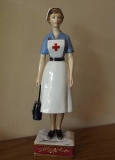 a figurine of a nurse standing on top of a wooden table next to a wall