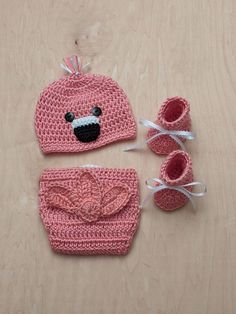 a crocheted bear hat and booties on a table