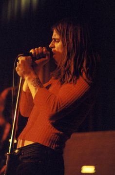 a woman singing into a microphone on stage